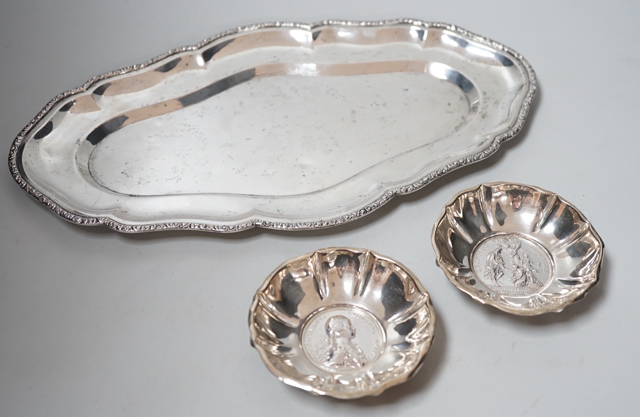 A 20th century Hungarian 800 standard white metal oval platter or stand, 33.2cm, and two 800 white metal bowls with inset coin bases, gross weight 15.5oz.